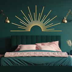 a bedroom with green walls and gold sunburst on the wall above the bed