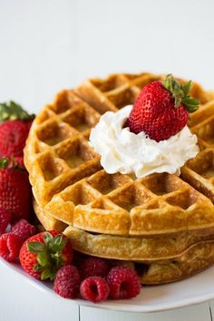 waffles with whipped cream and strawberries on the side