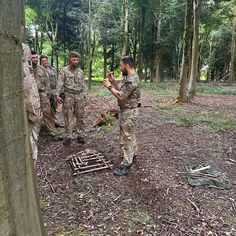 some soldiers are standing around in the woods