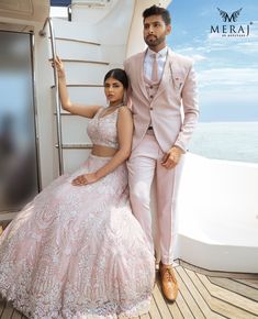 a man and woman in formal wear posing for a photo on the deck of a boat