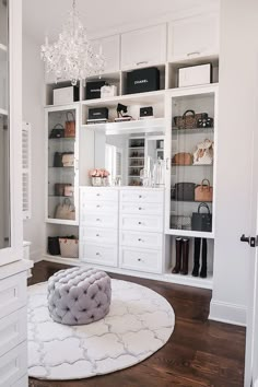 a living room with white furniture and shelves filled with purses, bags and handbags