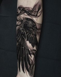 a black and white tattoo with a bird on it's arm, flying through the air