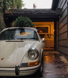 a white car parked in front of a house with a christmas tree on the hood