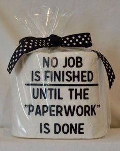 a white cake wrapped in plastic with black polka dots on it's wrapper that says, no job is finished until the paperwork is done