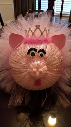 a pink rat with a tiara on it's head sitting on a table