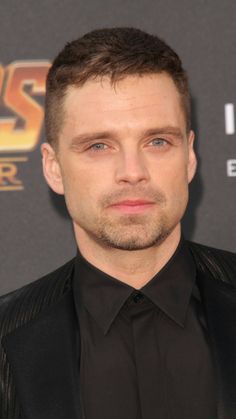 a close up of a person in a suit and tie at a red carpet event