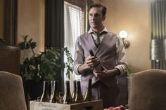 a man standing in front of a table filled with wine bottles