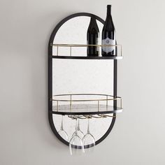 two wine glasses are sitting on a shelf next to a bottle and glass holder that is hanging from the wall