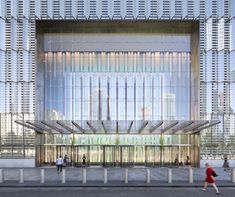 people walking in front of a large building with many windows on the outside and inside