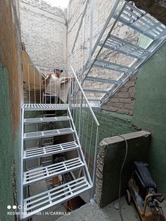 there is a metal staircase going up the side of a building with a dog sitting on it