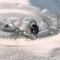 a black diamond ring sitting on top of a white plate