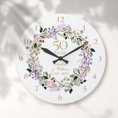 a white clock with flowers and leaves on it's face that says 50 years