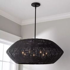 a black chandelier hanging from the ceiling in a room with white walls and windows