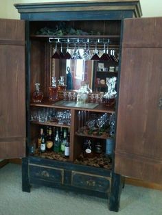 an old wooden cabinet with wine glasses on it