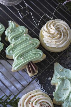 decorated cookies sitting on top of a cooling rack