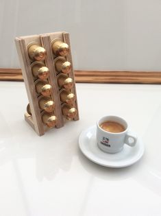 a cup of coffee sitting next to an egg carton with golden eggs in it