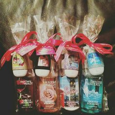 four bottles of bath products wrapped in cellophane and tied with red ribbon on the back of a couch