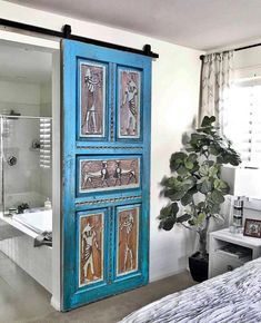 a blue door is opened to reveal a bathroom with a bathtub in the background