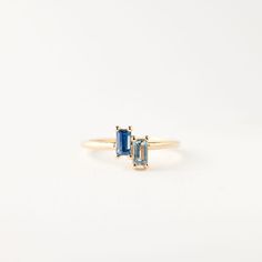 two stone ring in yellow gold with blue topazte and diamond accents on the sides