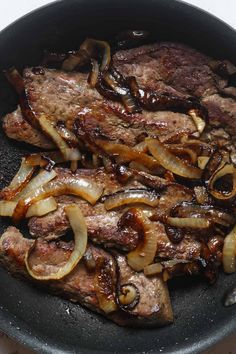 steak and onions cooking in a skillet