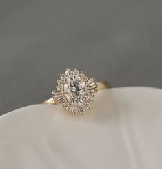 a diamond ring on top of a white plate with a gray background in the background