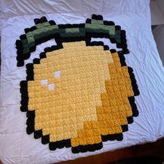 a bed topped with a yellow and black blanket