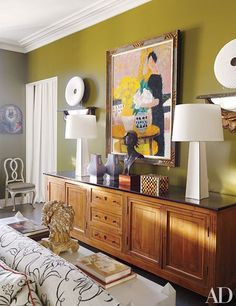 a living room filled with furniture and paintings on the wall