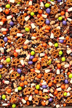 a tray filled with halloween pretzels, candy and sprinkles on top of it