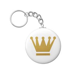 a white and gold keychain with a golden crown on the front, against a white background