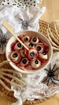 a white bowl filled with food on top of a table next to skeleton bones and spider legs