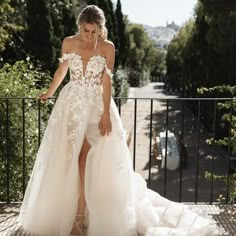 a woman in a wedding dress standing on a balcony