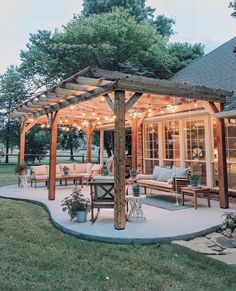 an outdoor patio with lights on the roof and seating area in the middle of it