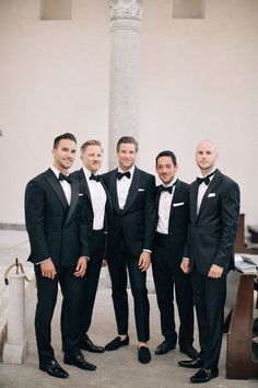 a group of men in tuxedos standing next to each other