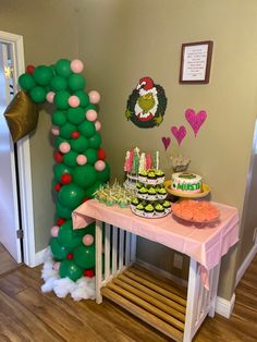 a table topped with lots of cakes and balloons