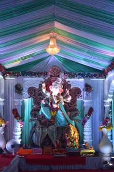 an idol sitting on top of a table under a white and blue tented ceiling