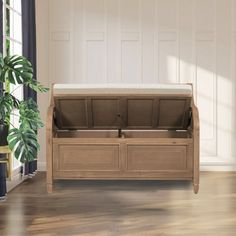 a wooden bench with two storage compartments on the bottom, and a potted plant next to it