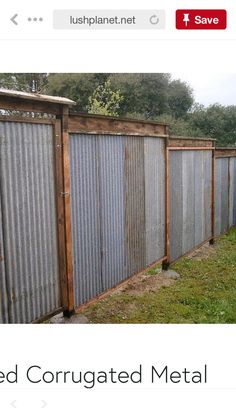 an old corrugated metal fence is being used as a garden divider for the yard