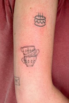 a person with a tattoo on their arm has a cupcake and a piece of cake