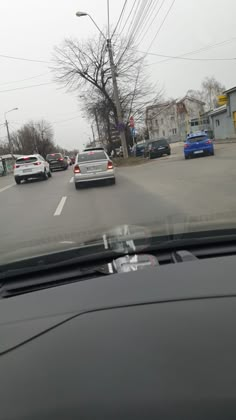 cars are driving down the road on a cloudy day