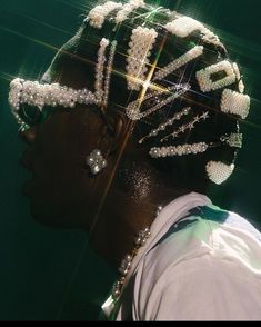 a close up of a person wearing a head piece with pearls on it's hair