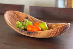 a wooden bowl filled with different types of fruit