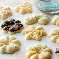 some cookies that are on a table with sprinkles and blue powdered sugar