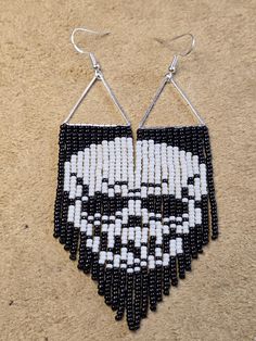 a pair of black and white beaded earrings with an image of a bearded man