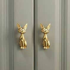 a gold cat door handle on a gray door