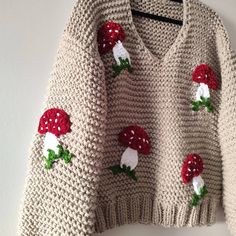 a knitted sweater with red and white flowers on it