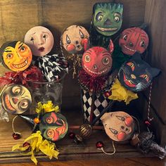 many different masks are on display in a wooden box with ribbons and decorations around them