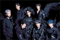 the members of exo are posing for a photo in front of black feathers and furs