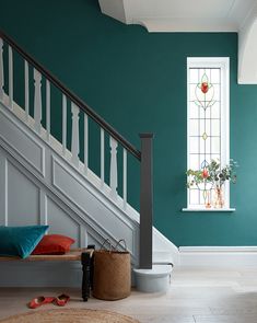 a living room with green walls and white stairs