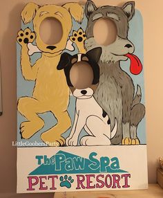 a cardboard cutout of two dogs and a cat with the words paws spa pet's resort on it