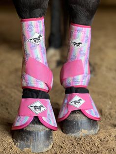 the legs and feet of a horse wearing pink boots with horses on it's sides